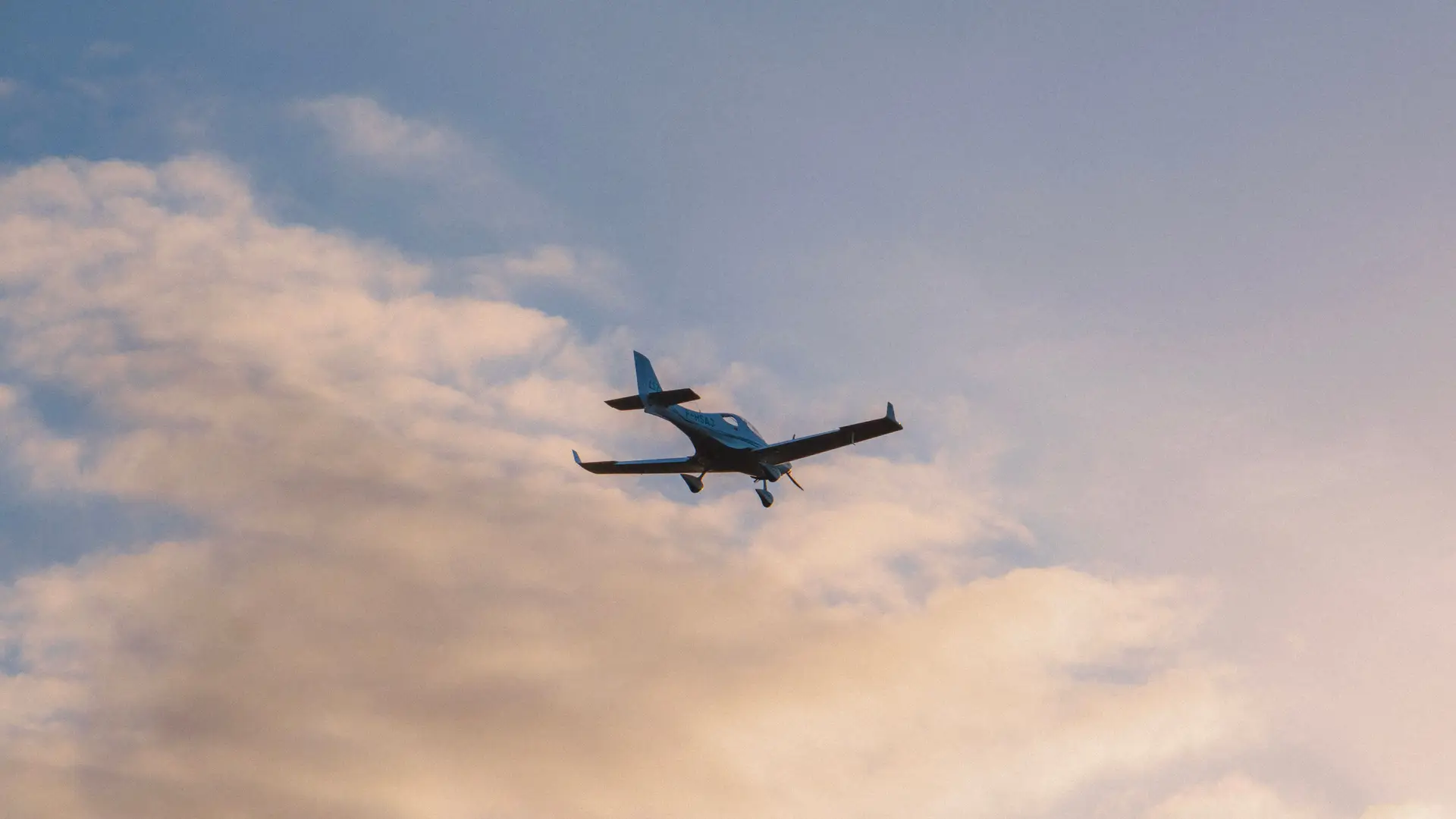 Private aircraft gliding gracefully above atmospheric clouds in Canadian airspace