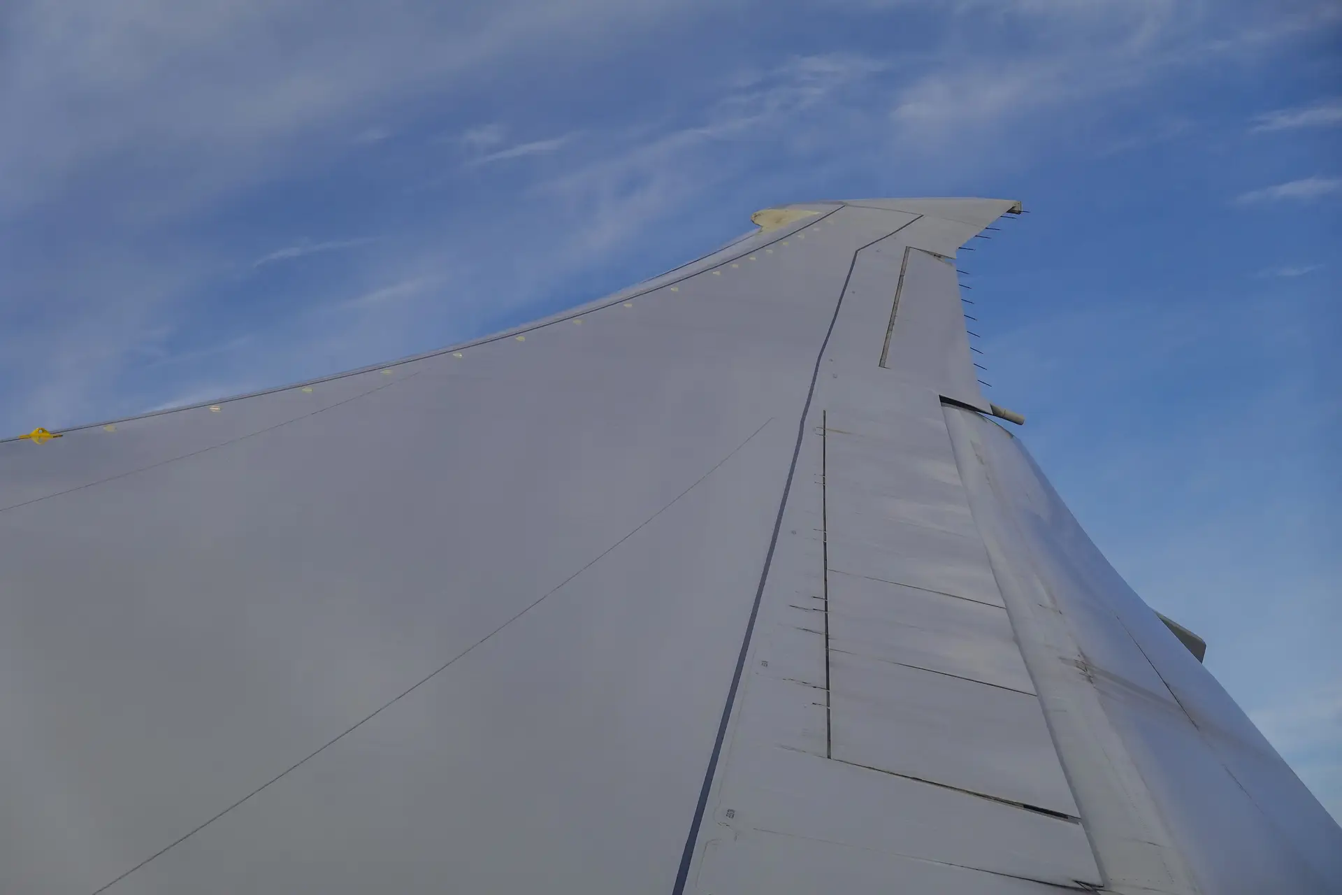 Commercial airliner wing in high altitude flight over clouds