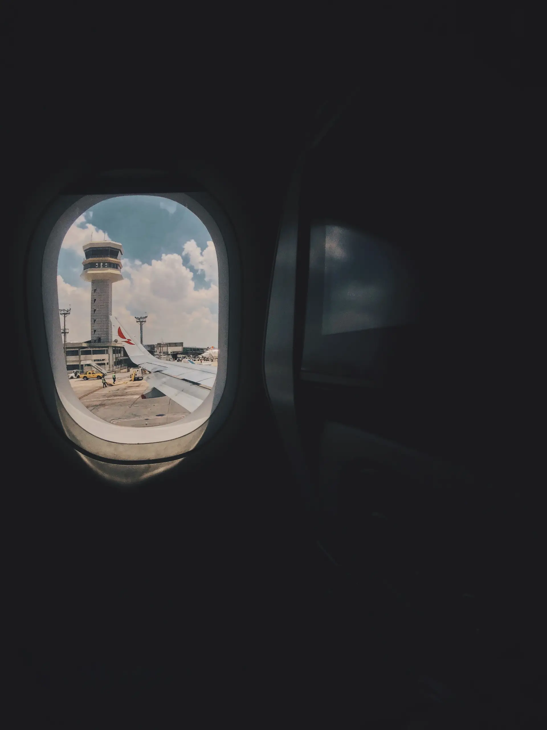 View from passenger window showing control tower and quiet tarmac