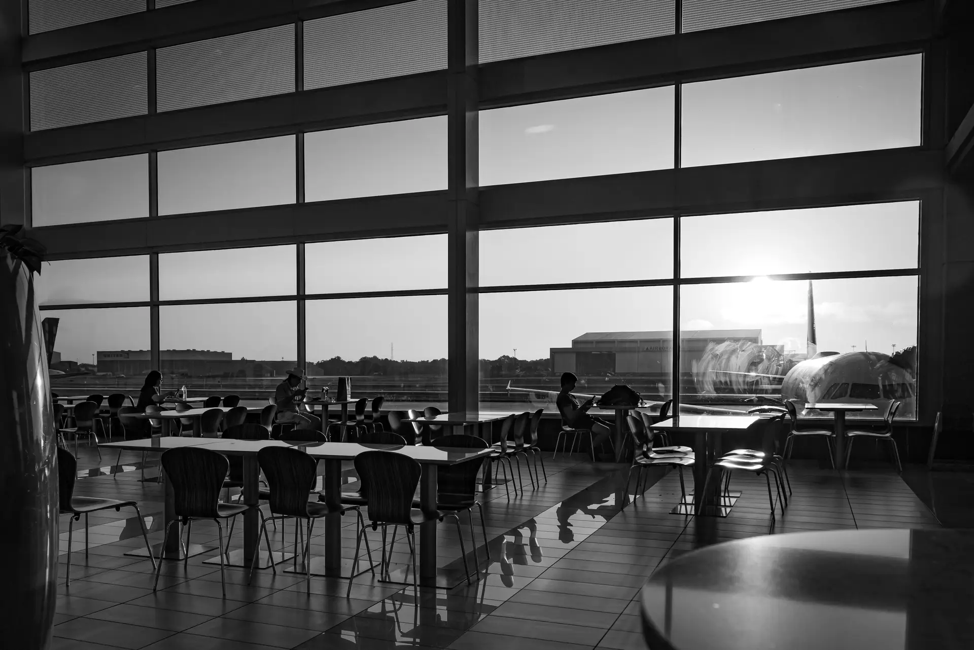 Architectural glass windows of modern private flight lounge with warm sunlight