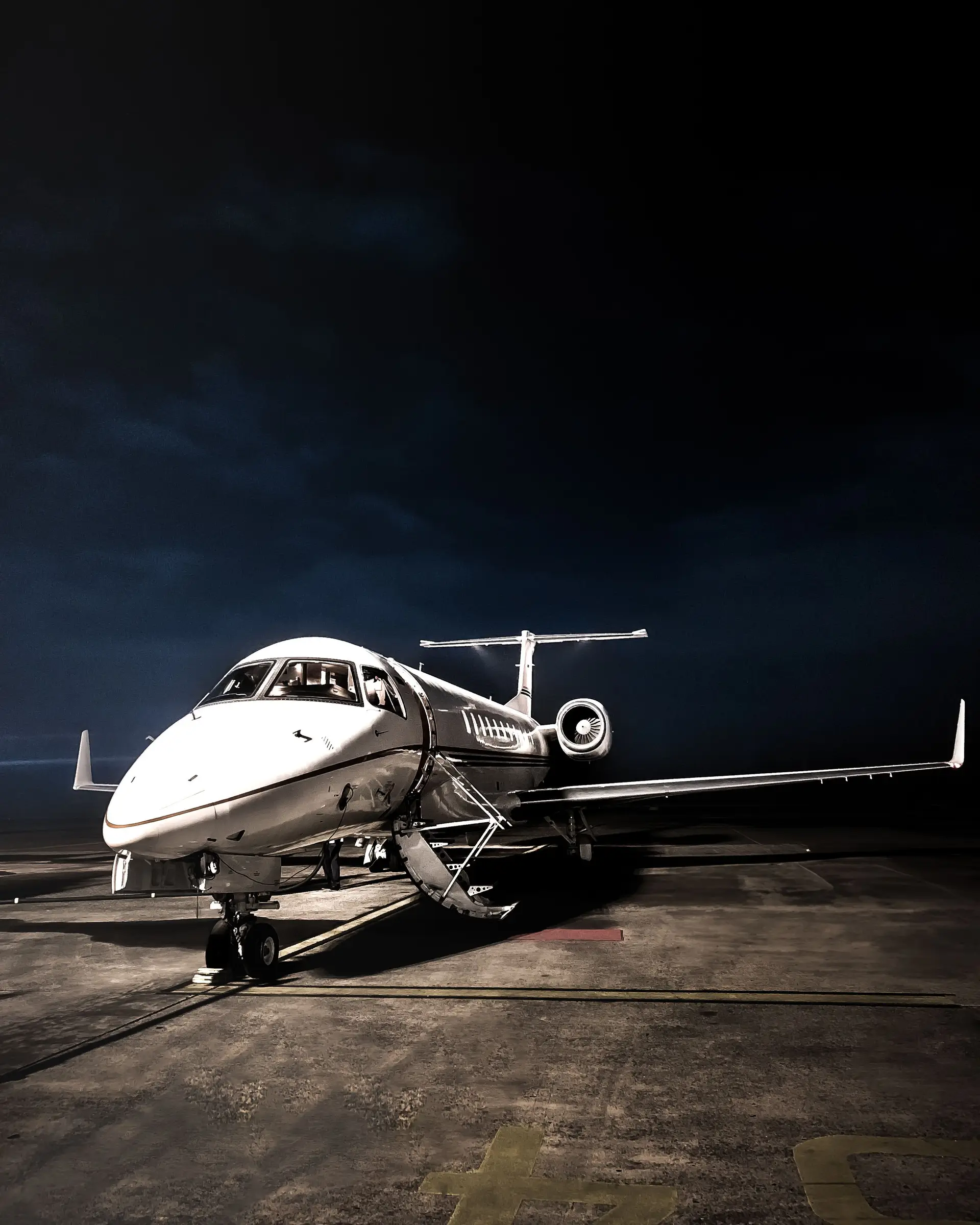 Private executive aircraft ready on tarmac under evening lighting