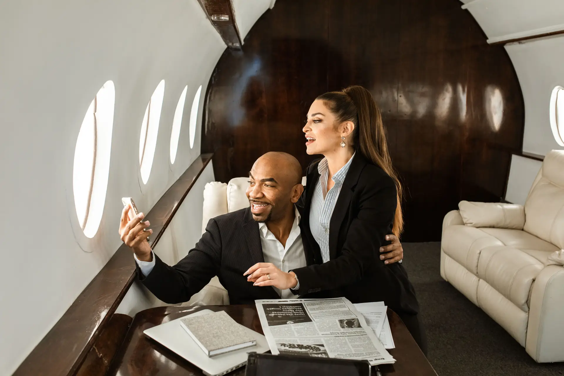 Executive couple relaxed in cabin seats with refreshment glasses during smooth long-haul flight