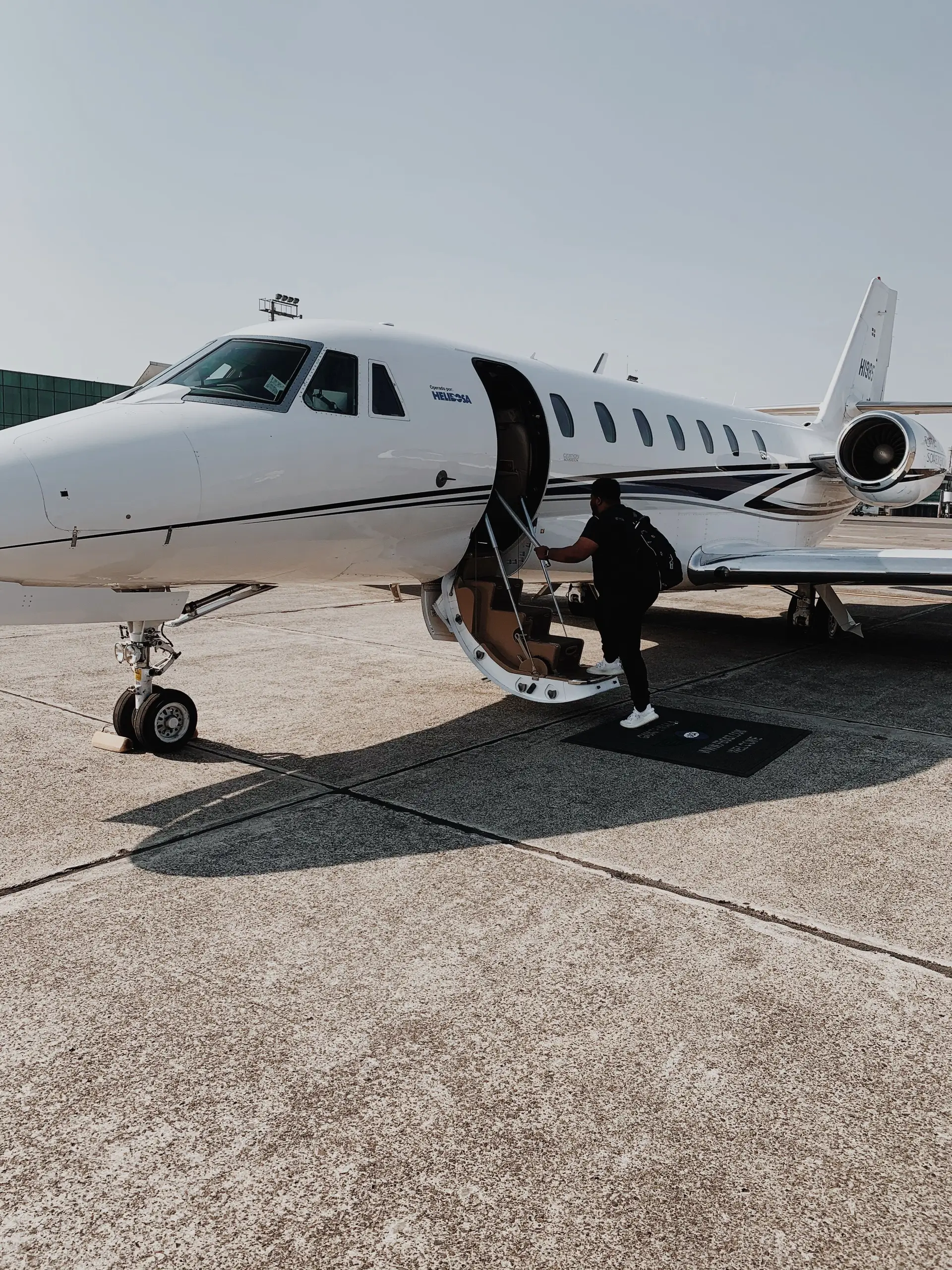 Traveller boarding private jet on quiet morning tarmac